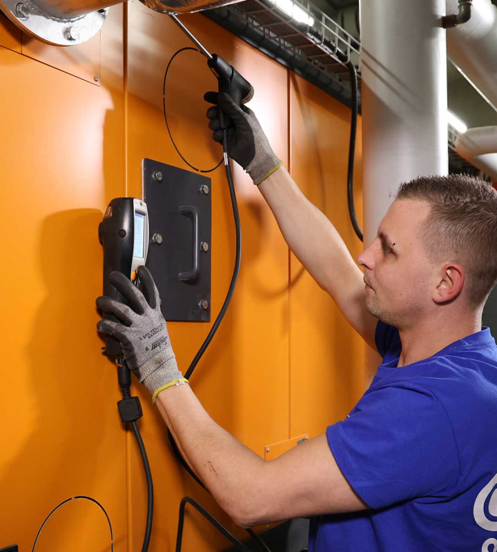 Un collaborateur de Groupe E effectue la maintenance préventive d'une centrale de chauffe.