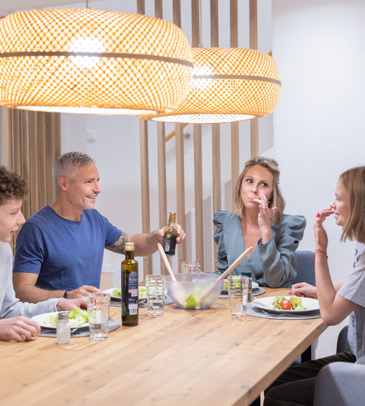 Couple dans un intérieur moderne et confortable, illustrant les avantages du raccordement au chauffage à distance de Groupe E