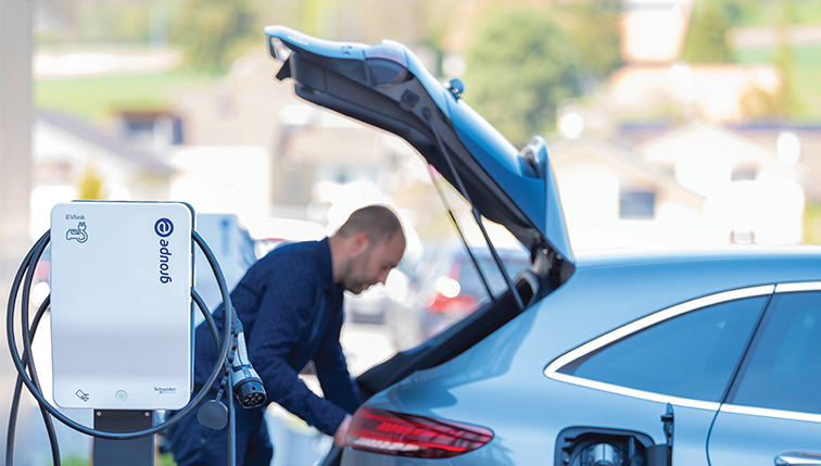 un homme devant le coffre ouvert de sa voiture