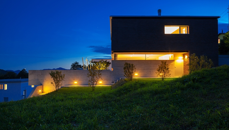 Une villa de nuit, avec les lumières allumées, consommant sa propre production d'électricité