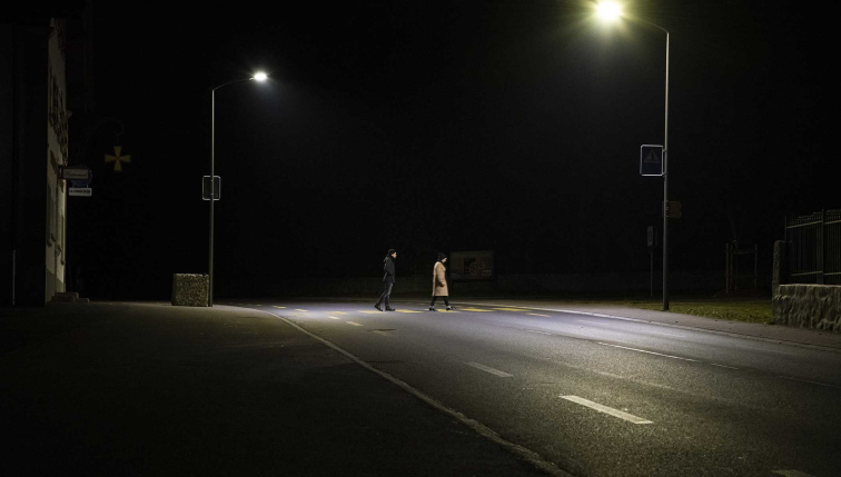 Deux personnes traversant un passage piéton de nuit