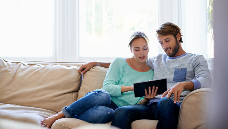 jeune couple qui suit sa consommation grâce au compteur intelligent installé par Groupe E