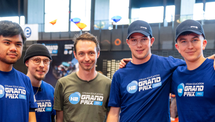 Eine Gruppe junger Teilnehmer am H2 Grand Prix, einer Bildungsinitiative zu Wasserstofftechnologien, posiert gemeinsam für ein Foto. Einige tragen Mützen und T-Shirts von Groupe E, was ihre Teilnahme am Wettbewerb und ihr Engagement für nachhaltige Energien und technologische Innovationen zeigt.